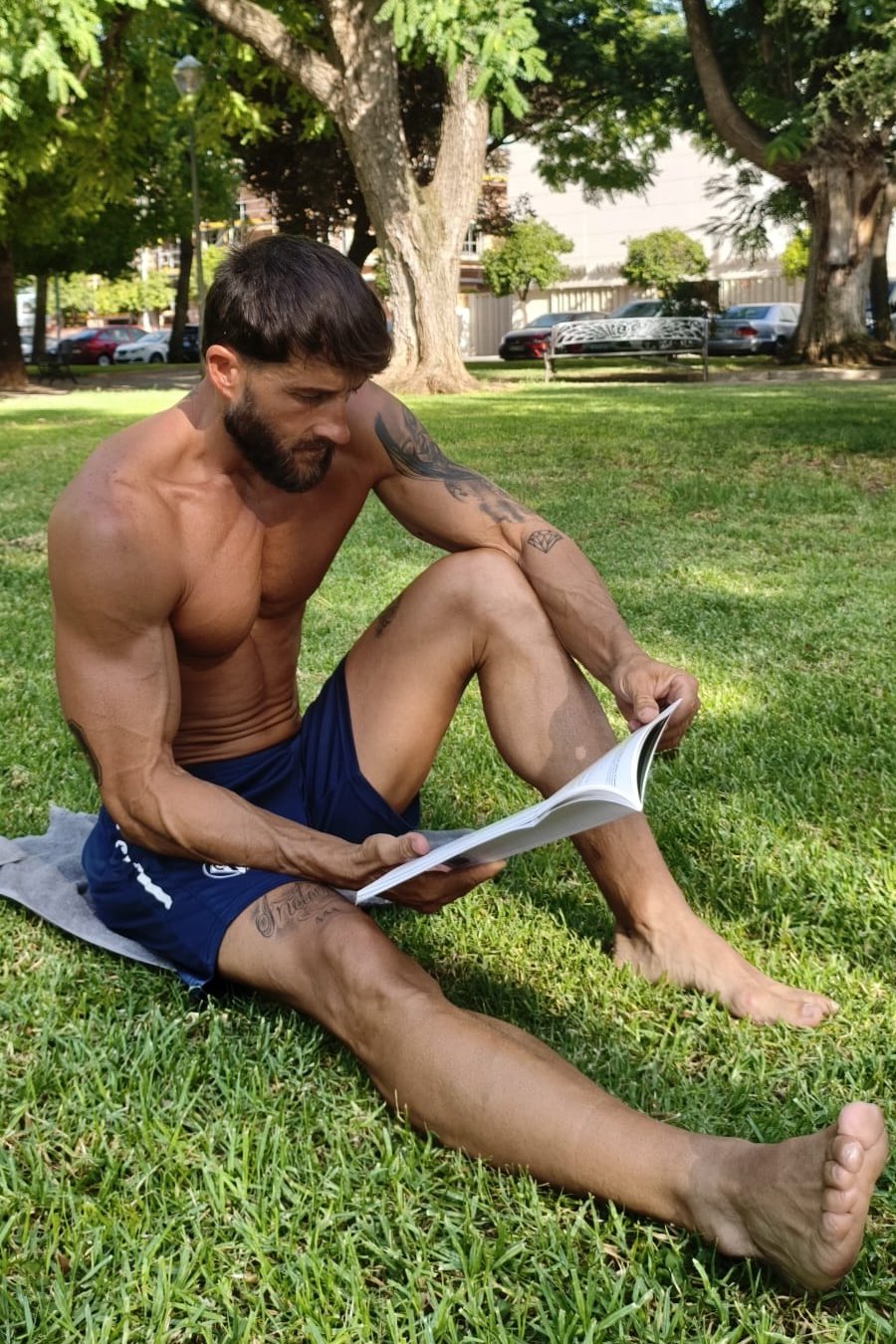 Carlos Cortés leyendo descalzo en el césped de un parque, Córdoba